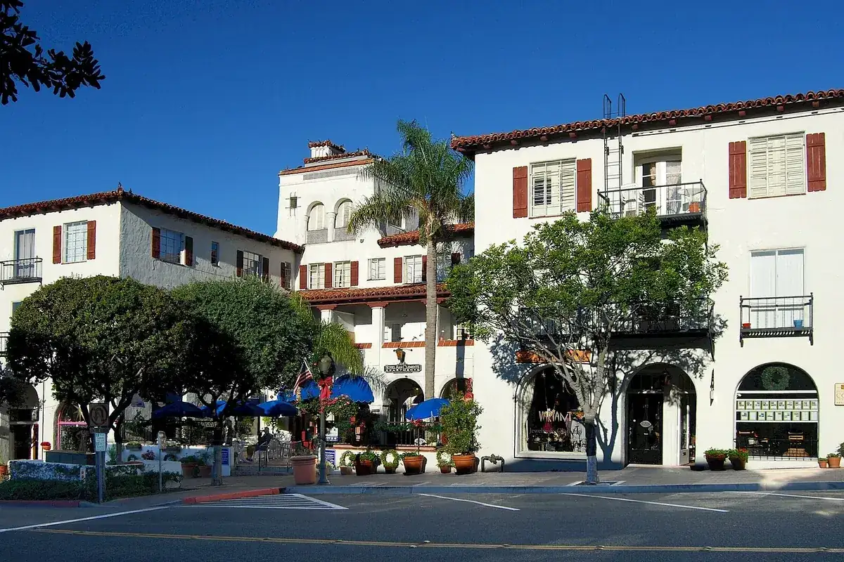 White stucco buildings with red clay tile roofs and dark timber shutters on Avenida Del Mar in San Clemente CA