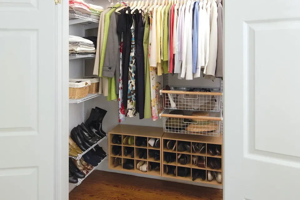 A walk-in closet with double hanging rails, a shoe cubby run and storage baskets over a hardwood floor in a San Clemente CA style home