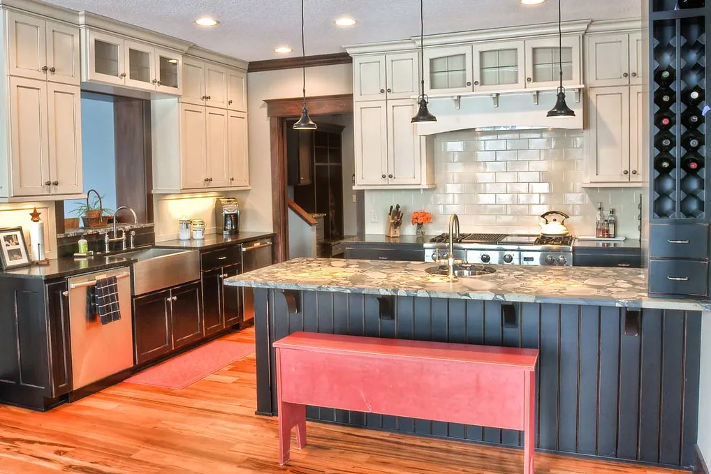 Painted perimeter cabinets, a dark island and a tall wine cabinet in a Southern California kitchen of the kind built in San Clemente CA