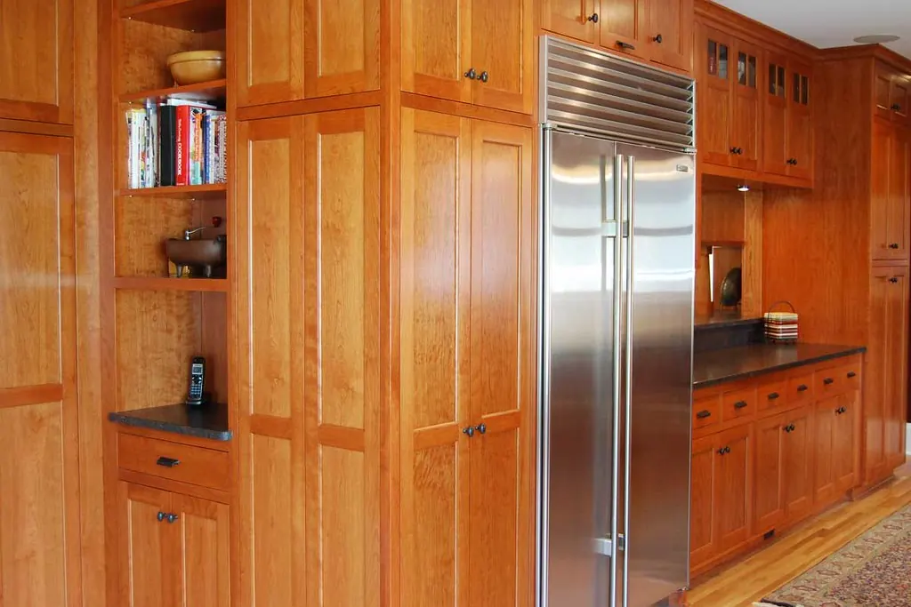 Floor to ceiling natural wood cabinetry with an integrated refrigerator panel, of the kind fitted in newer Talega homes in San Clemente CA