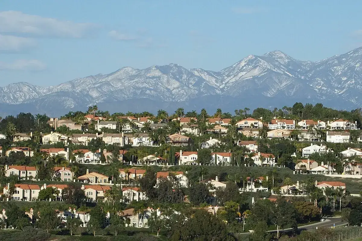 Rows of tile roofed tract homes on a hillside in Laguna Niguel CA with the Santa Ana Mountains behind