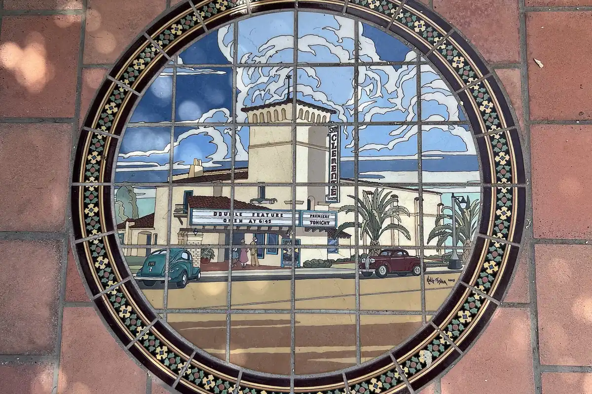 A round tile mural set into the sidewalk depicting the Miramar Theatre on Avenida Del Mar in San Clemente CA