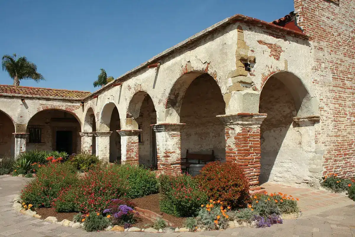 The arched adobe and brick corridor at Mission San Juan Capistrano in San Juan Capistrano CA