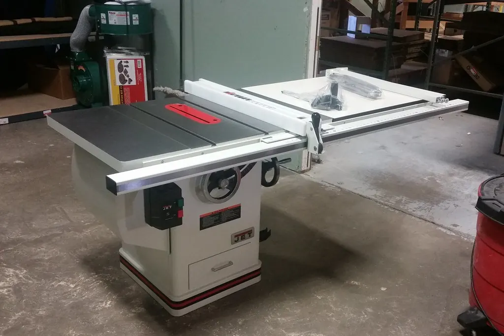 A cabinet shop table saw and bandsaw set up on a workshop floor of the kind that builds cabinets for San Clemente CA homes